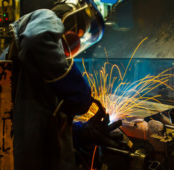 worker with protective mask welding metal