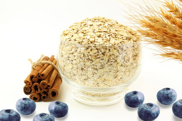 Wall Mural - oatmeal in bowl with blueberry cinnamon and oats ears on white background