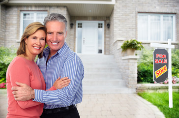 Wall Mural - Happy senior couple near new house.