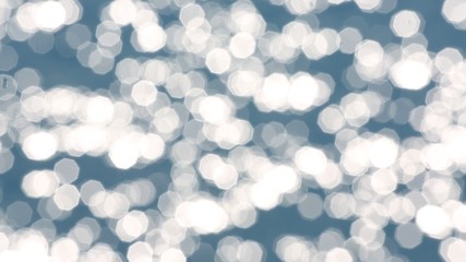 Bokeh background of blue sea water with sun reflections