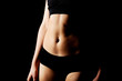 © Piotr Marcinski - Belly of slim young woman in black sports underwear