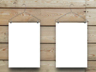 Close-up of two hanged blank frames with clothes hangers on horizontal brown wooden boards background