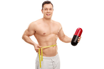 Poster - Handsome man holding a huge diet pill