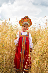 Wall Mural - Girl in Russian national sundress standing in a wheat field