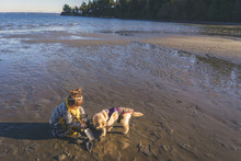 Girl With Golden Retriever Puppy Dog Digging On Beach