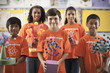 © Mint Images - A group of girls and boys wearing the teeshirt of the Science Club, making molecular structure models,