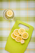 Lemon water and sliced lemons on a fabric background