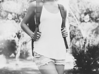 Canvas Print - Young girl wearing blank t-shirt and backpack. Outdoor background. Horizontal mockup, blurred, bokeh effect. Black white