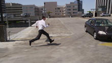 Businessman Jumps Over Car In Parking Lot, Slow Motion