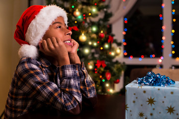 Boy in Santa hat smiling.