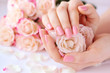 Hands of a woman with pink manicure on nails  and roses