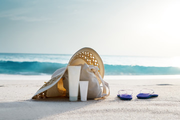 Wall Mural - sun lotion, hat with bag at the tropical beach