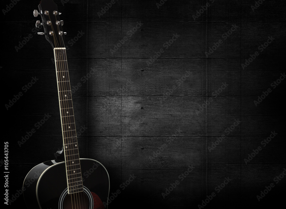 Black acoustic guitar on dark black wooden background. - obrazy, fototapety, plakaty 