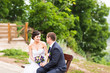 © satura_ - attractive bride and groom  sitting on a bench