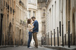 © Mint Images - Couple standing gazing at each other, in narrow street in city