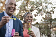 © Mint Images - A mature couple, man and woman blowing bubbles celebrating an occasion outdoors,