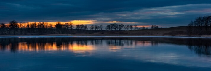 Close up of opposite shore of lake after sunset