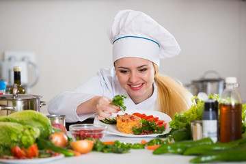 Wall Mural - Happy cook preparing vegetable salad with cheese