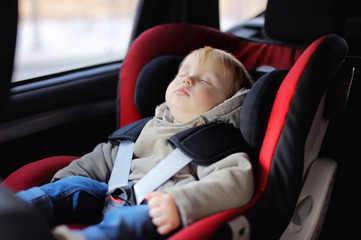 Toddler boy sleeping in car seat