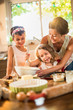 © jackfrog - A mother is cooking a cake with her two young daughters