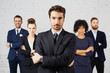 © baranq - Group of business people standing in office with male leader at