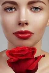 Canvas Print - Close-up beautiful young woman with bright lipgloss makeup. Perfect clean skin, sexy red lip make-up. Beautiful valentine visage with red rose flower. Romantic and sexy look for Valentines day