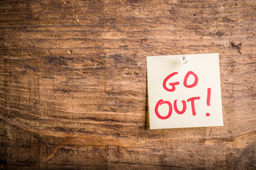 go out! - motivation paper note on wood noticeboard