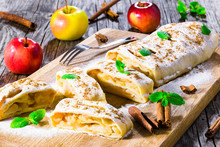 baked homemade apple strudel with powdered sugar and mint leaves