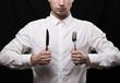 portrait of a young man in a white shirt with a knife and fork i