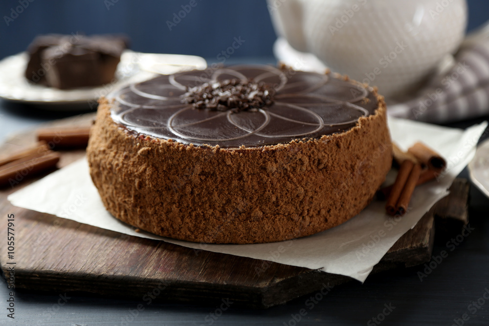 Tasty chocolate cake on color wooden background