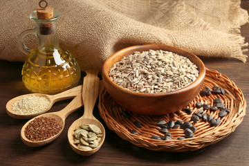 Wall Mural - Sunflower oil and seeds on wooden table background, closeup