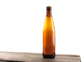 Unlabeled beer bottle on wooden table against white background