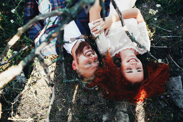 Wall Mural - Cute positive couple lying on the grass