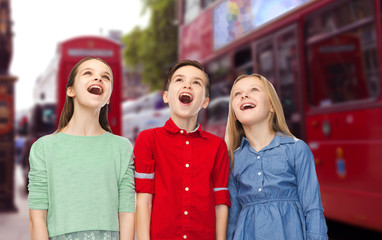 Canvas Print - amazed boy and girls looking up over london city