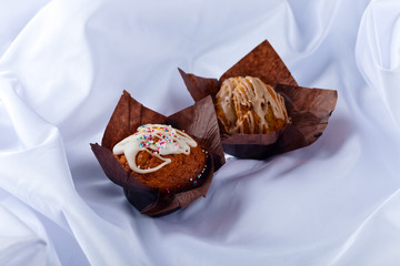 two muffins on white tablecloth