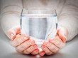 A glass of clean mineral water in woman's hands. Environment protection, healthy drink.