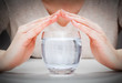 © Photocreo Bednarek - A glass of clean mineral water covered by woman's hands. Environment protection