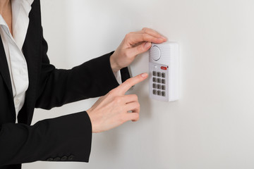 woman hand pressing button on security system