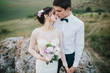 © anatoliycherkas - Beautiful wedding couple with bouquet flowers on the sunset