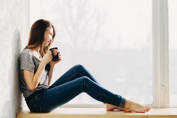 Beautiful girl is dreaming by the window