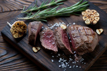 Wall Mural - Sliced medium rare grilled asado steak on a wooden serving board