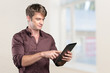 © fotofabrika - Smiling young man using tablet computer