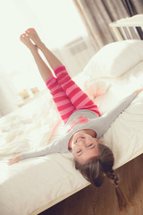 Wall Mural - Child doing exercises while lying in bed