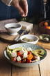 © Silvia Pascual/ADDICTIVE STOCK - Dressing cherries tomato salad with feta cheese, avocados and oi