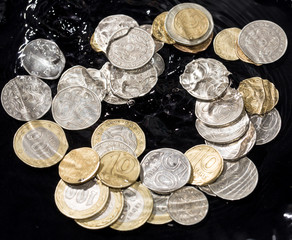 coins in water splashes on a black background