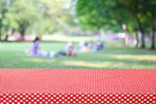 Empty Table And Red Tablecloth Over Blur Park With People