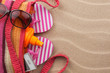 Beach bag with sunscreen, flip flops, cellphone, sunglasses.