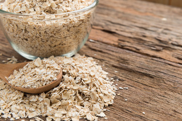 Dry rolled oat flakes oatmeal on old wooden table