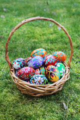 Wall Mural - colored easter eggs in basket on spring grass