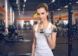 © podushko - Strong woman weightlifting at the gym looking happy and working on her biceps